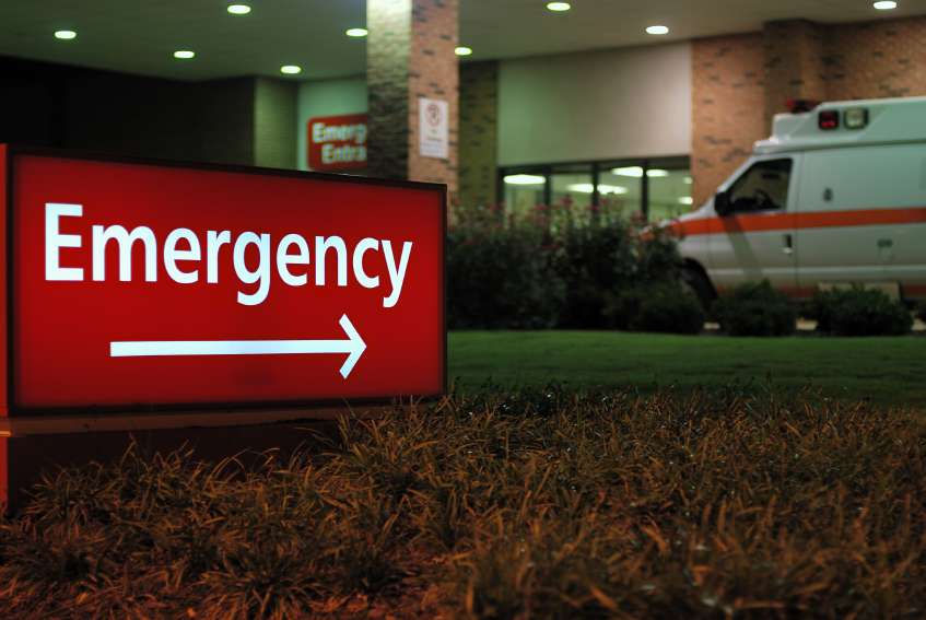 Red emergency sign points toward a hospital
